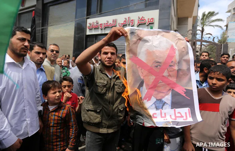 Hamas supporters hold crossed posters depicting Palestinian President Mahmoud Abbas and Palestinian Prime Minister Rami Hamdallah during a protest against them in Khan Younis in the southern Gaza Strip April 14, 2017. Ph...