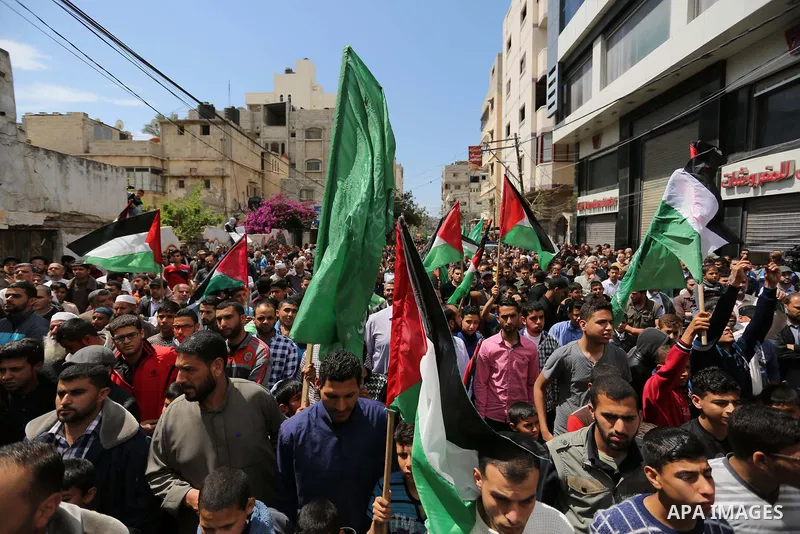 Hamas supporters hold crossed posters depicting Palestinian President Mahmoud Abbas and Palestinian Prime Minister Rami Hamdallah during a protest against them in Khan Younis in the southern Gaza Strip April 14, 2017. Ph...