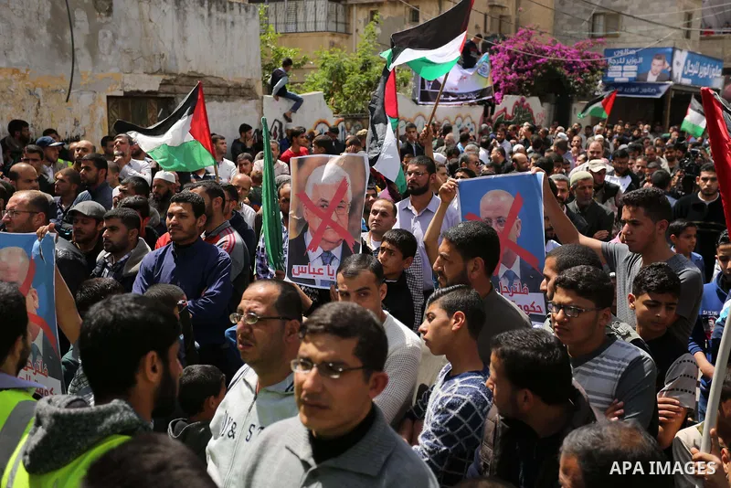 Hamas supporters hold crossed posters depicting Palestinian President Mahmoud Abbas and Palestinian Prime Minister Rami Hamdallah during a protest against them in Khan Younis in the southern Gaza Strip April 14, 2017. Ph...