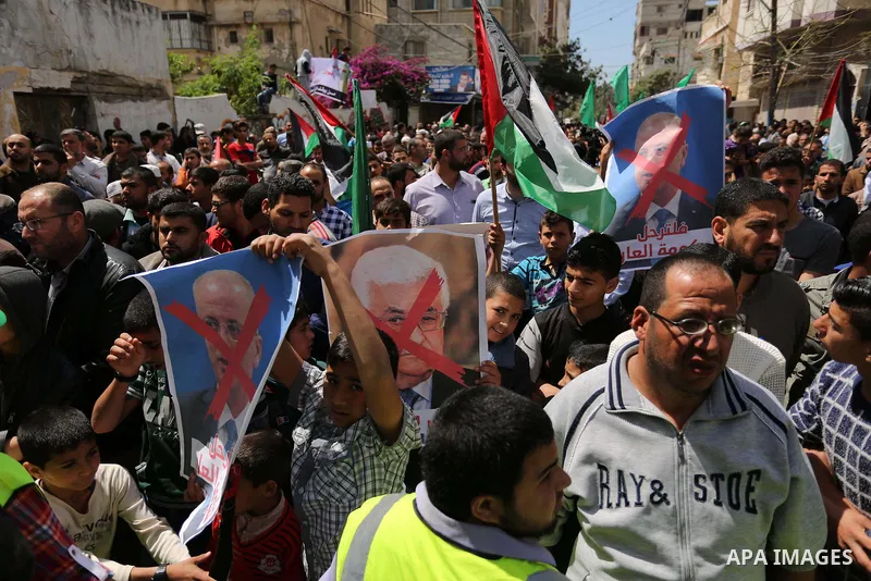 Hamas supporters hold crossed posters depicting Palestinian President Mahmoud Abbas and Palestinian Prime Minister Rami Hamdallah during a protest against them in Khan Younis in the southern Gaza Strip April 14, 2017. Ph...