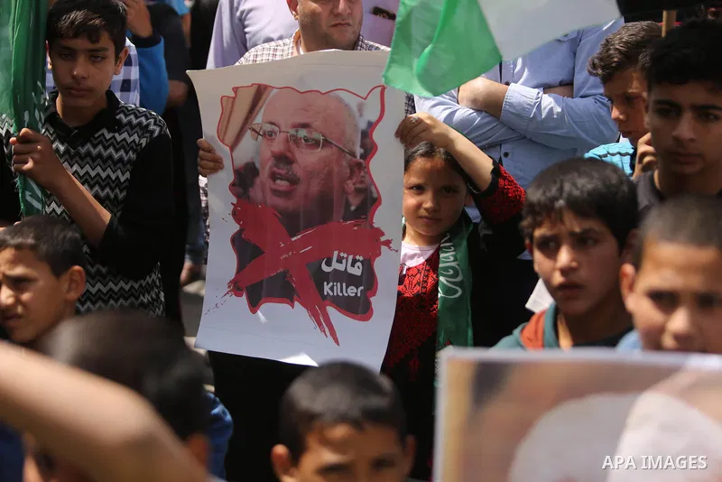 Hamas supporters hold crossed posters depicting Palestinian President Mahmoud Abbas and Palestinian Prime Minister Rami Hamdallah during a protest against them in Khan Younis in the southern Gaza Strip April 14, 2017. Ph...