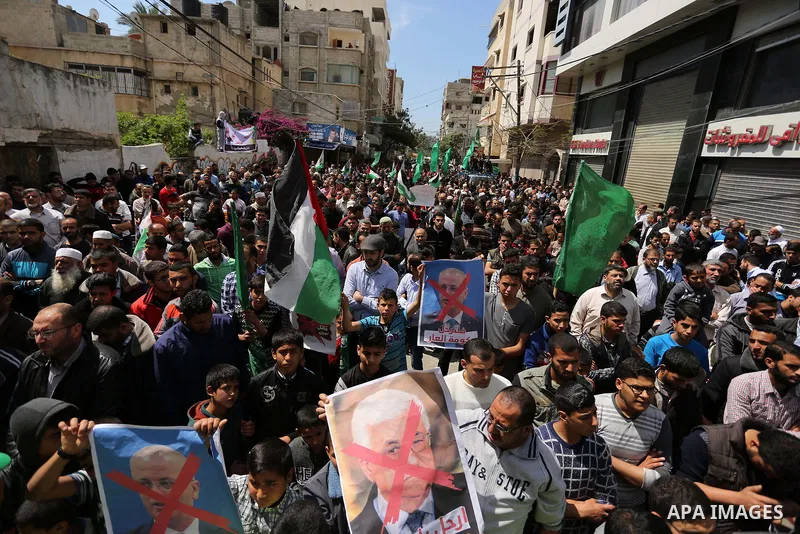Hamas supporters hold crossed posters depicting Palestinian President Mahmoud Abbas and Palestinian Prime Minister Rami Hamdallah during a protest against them in Khan Younis in the southern Gaza Strip April 14, 2017. Ph...