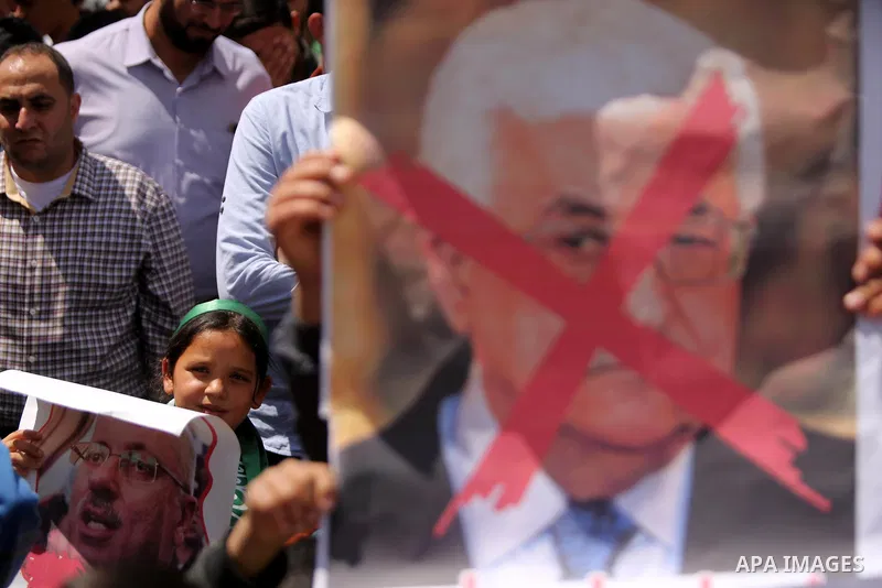 Hamas supporters hold crossed posters depicting Palestinian President Mahmoud Abbas and Palestinian Prime Minister Rami Hamdallah during a protest against them in Khan Younis in the southern Gaza Strip April 14, 2017. Ph...