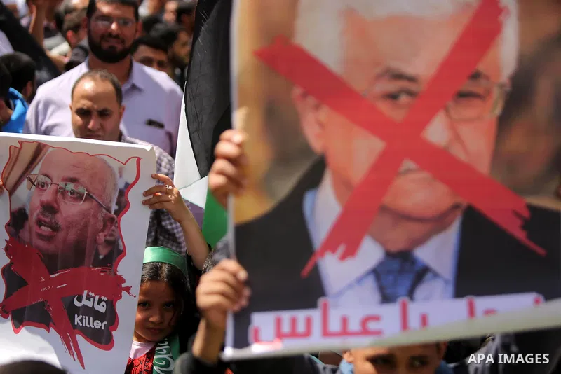 Hamas supporters hold crossed posters depicting Palestinian President Mahmoud Abbas and Palestinian Prime Minister Rami Hamdallah during a protest against them in Khan Younis in the southern Gaza Strip April 14, 2017. Ph...