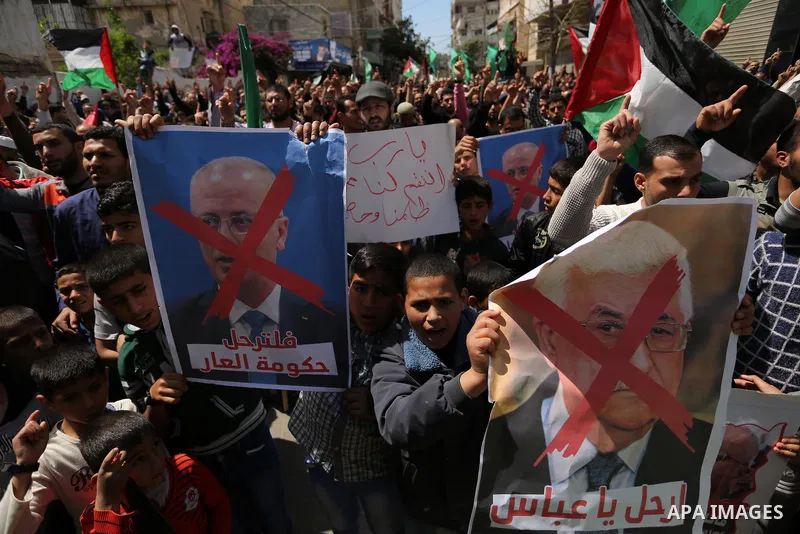 Hamas supporters hold crossed posters depicting Palestinian President Mahmoud Abbas and Palestinian Prime Minister Rami Hamdallah during a protest against them in Khan Younis in the southern Gaza Strip April 14, 2017. Ph...