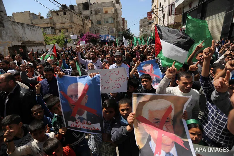 Hamas supporters hold crossed posters depicting Palestinian President Mahmoud Abbas and Palestinian Prime Minister Rami Hamdallah during a protest against them in Khan Younis in the southern Gaza Strip April 14, 2017. Ph...