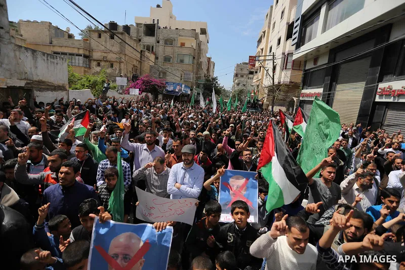 Hamas supporters hold crossed posters depicting Palestinian President Mahmoud Abbas and Palestinian Prime Minister Rami Hamdallah during a protest against them in Khan Younis in the southern Gaza Strip April 14, 2017. Ph...