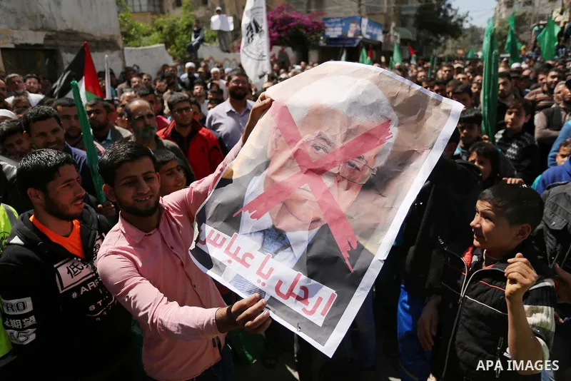 Hamas supporters hold crossed posters depicting Palestinian President Mahmoud Abbas and Palestinian Prime Minister Rami Hamdallah during a protest against them in Khan Younis in the southern Gaza Strip April 14, 2017. Ph...