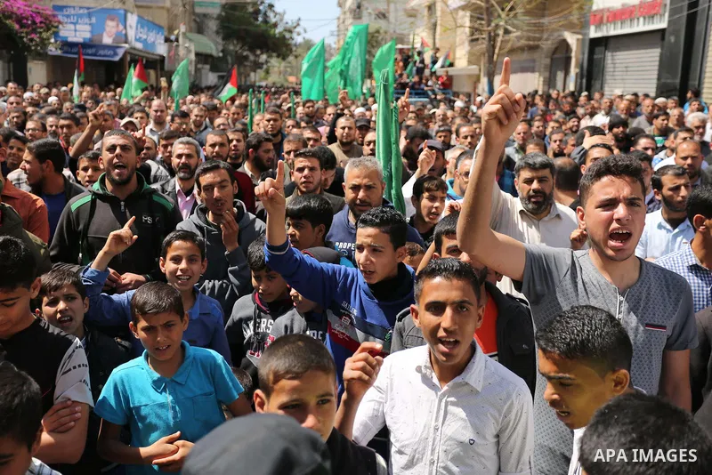 Hamas supporters hold crossed posters depicting Palestinian President Mahmoud Abbas and Palestinian Prime Minister Rami Hamdallah during a protest against them in Khan Younis in the southern Gaza Strip April 14, 2017. Ph...