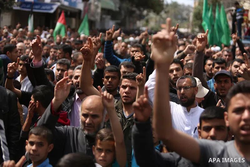 Hamas supporters hold crossed posters depicting Palestinian President Mahmoud Abbas and Palestinian Prime Minister Rami Hamdallah during a protest against them in Khan Younis in the southern Gaza Strip April 14, 2017. Ph...
