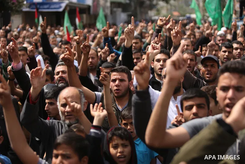 Hamas supporters hold crossed posters depicting Palestinian President Mahmoud Abbas and Palestinian Prime Minister Rami Hamdallah during a protest against them in Khan Younis in the southern Gaza Strip April 14, 2017. Ph...