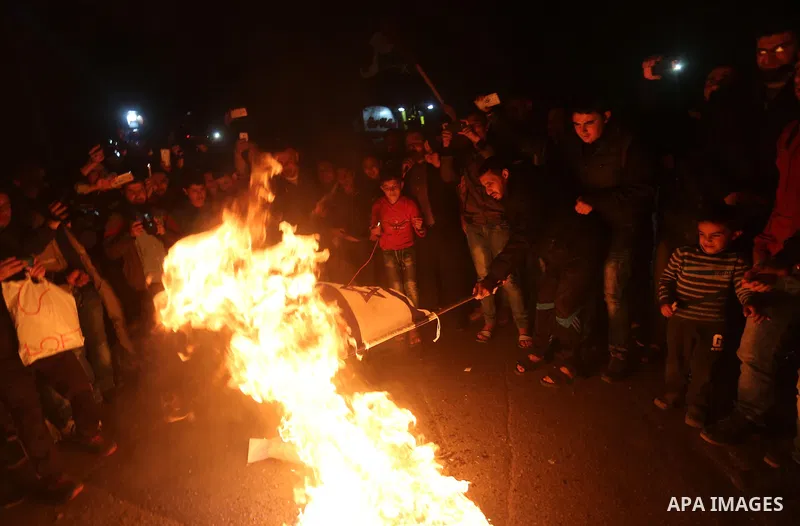 Supporters of the Palestinian Hamas movement burn an Israeli flag during a protest against the Israeli blockade of the Gaza Strip, in Gaza city, on April 14, 2017. Photo by Mohammed Asad