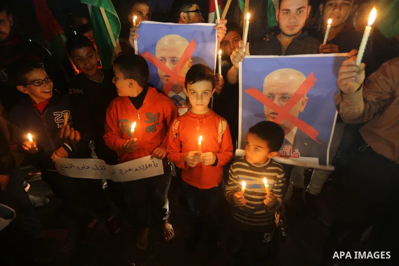 Supporters of the Palestinian Hamas movement hold placards and light candles during a protest against the Israeli blockade of the Gaza Strip, in Gaza city, on April 14, 2017. Photo by Mohammed Asad