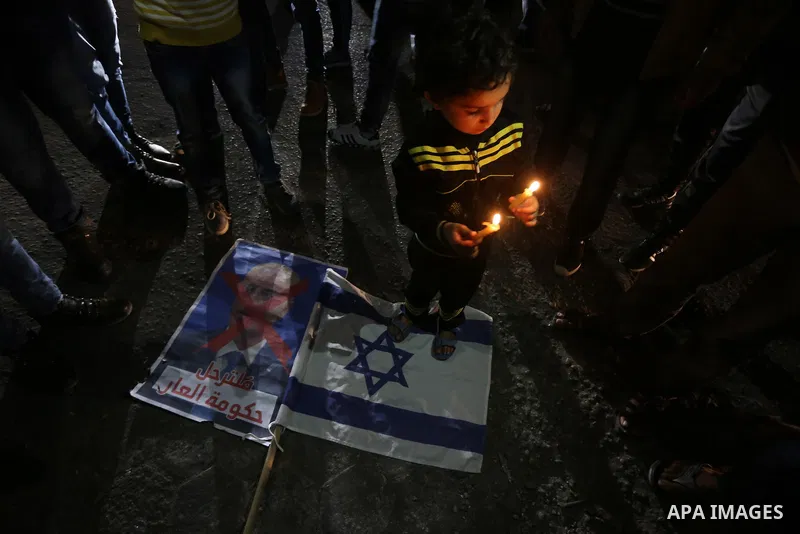 Supporters of the Palestinian Hamas movement hold placards and light candles during a protest against the Israeli blockade of the Gaza Strip, in Gaza city, on April 14, 2017. Photo by Mohammed Asad