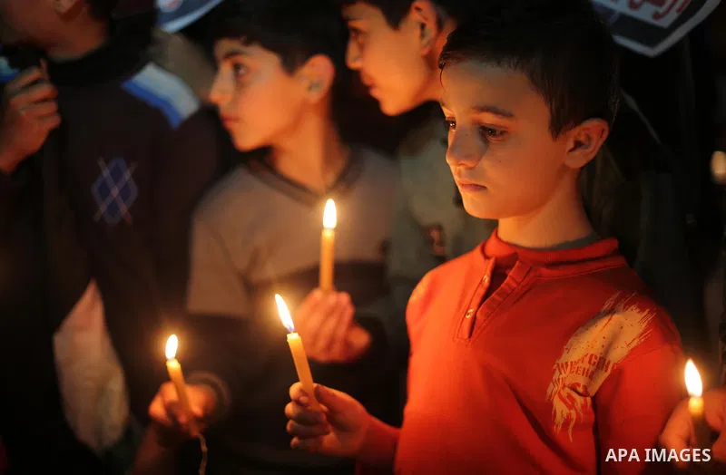Supporters of the Palestinian Hamas movement hold placards and light candles during a protest against the Israeli blockade of the Gaza Strip, in Gaza city, on April 14, 2017. Photo by Mohammed Asad