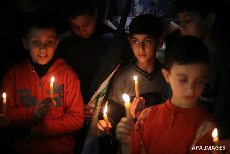 Supporters of the Palestinian Hamas movement hold placards and light candles during a protest against the Israeli blockade of the Gaza Strip, in Gaza city, on April 14, 2017. Photo by Mohammed Asad