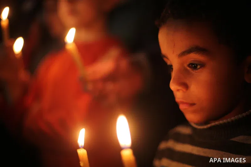 Supporters of the Palestinian Hamas movement hold placards and light candles during a protest against the Israeli blockade of the Gaza Strip, in Gaza city, on April 14, 2017. Photo by Mohammed Asad
