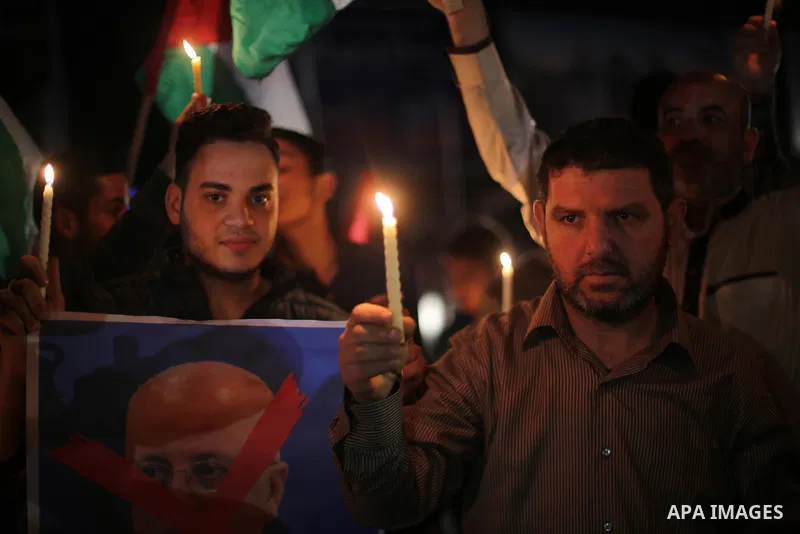 Supporters of the Palestinian Hamas movement hold placards and light candles during a protest against the Israeli blockade of the Gaza Strip, in Gaza city, on April 14, 2017. Photo by Mohammed Asad