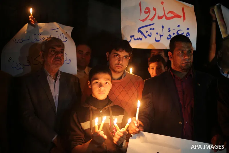 Supporters of the Palestinian Hamas movement hold placards and light candles during a protest against the Israeli blockade of the Gaza Strip, in Gaza city, on April 14, 2017. Photo by Mohammed Asad