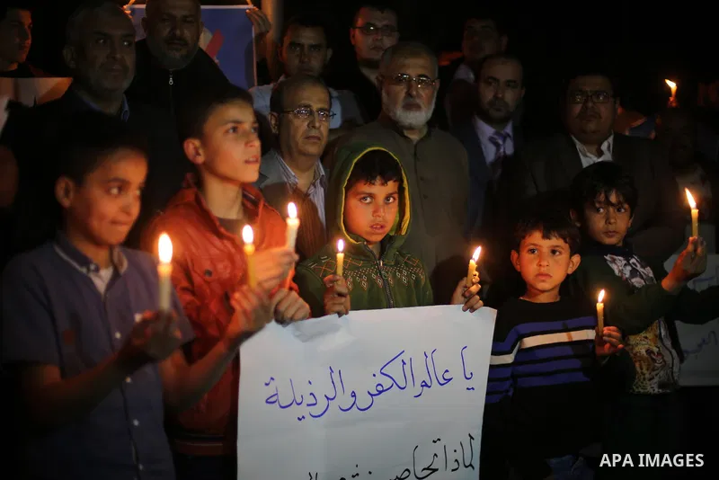 Supporters of the Palestinian Hamas movement hold placards and light candles during a protest against the Israeli blockade of the Gaza Strip, in Gaza city, on April 14, 2017. Photo by Mohammed Asad