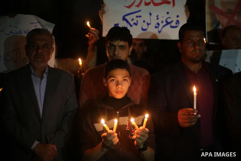 Supporters of the Palestinian Hamas movement hold placards and light candles during a protest against the Israeli blockade of the Gaza Strip, in Gaza city, on April 14, 2017. Photo by Mohammed Asad