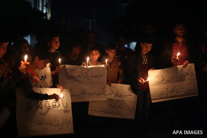 Supporters of the Palestinian Hamas movement hold placards and light candles during a protest against the Israeli blockade of the Gaza Strip, in Gaza city, on April 14, 2017. Photo by Mohammed Asad