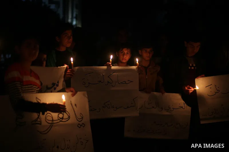 Supporters of the Palestinian Hamas movement hold placards and light candles during a protest against the Israeli blockade of the Gaza Strip, in Gaza city, on April 14, 2017. Photo by Mohammed Asad