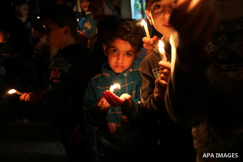 Supporters of the Palestinian Hamas movement hold placards and light candles during a protest against the Israeli blockade of the Gaza Strip, in Khan Younis in the southern Gaza Strip, on April 14, 2017. Photo by Ashraf...