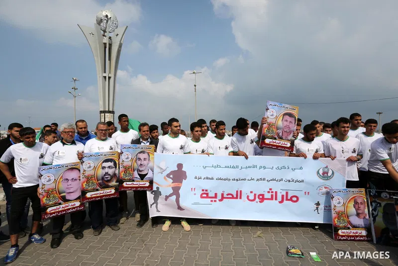 Palestinians hold banners as they take part in "Freedom Marathon" against the Israeli blockade of the Gaza Strip, in Gaza city on April 15, 2017. Photo by Ashraf Amra