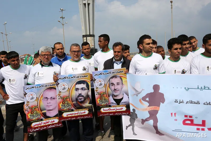 Palestinians hold banners as they take part in "Freedom Marathon" against the Israeli blockade of the Gaza Strip, in Gaza city on April 15, 2017. Photo by Ashraf Amra
