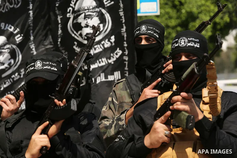 Palestinian militants of the Nasser Salah al-Din Brigades the military wing of the Popular Resistance movement hold their weapons during a press conference, in Gaza City on April 15, 2017. Photo by Ashraf Amra