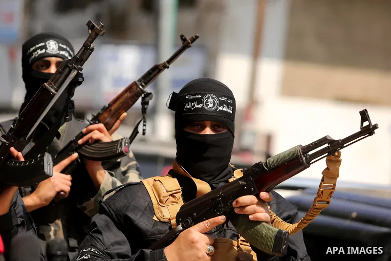Palestinian militants of the Nasser Salah al-Din Brigades the military wing of the Popular Resistance movement hold their weapons during a press conference, in Gaza City on April 15, 2017. Photo by Ashraf Amra