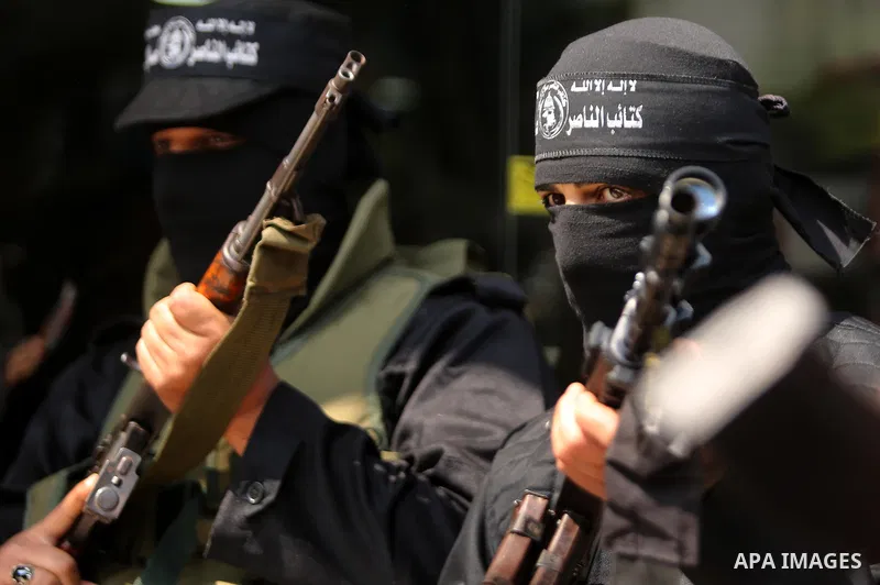 Palestinian militants of the Nasser Salah al-Din Brigades the military wing of the Popular Resistance movement hold their weapons during a press conference, in Gaza City on April 15, 2017. Photo by Ashraf Amra