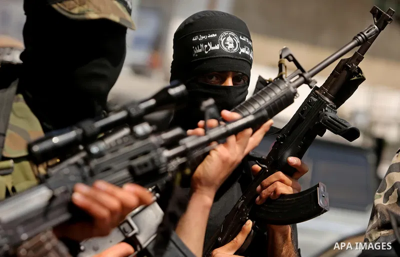 Palestinian militants of the Nasser Salah al-Din Brigades the military wing of the Popular Resistance movement hold their weapons during a press conference, in Gaza City on April 15, 2017. Photo by Ashraf Amra