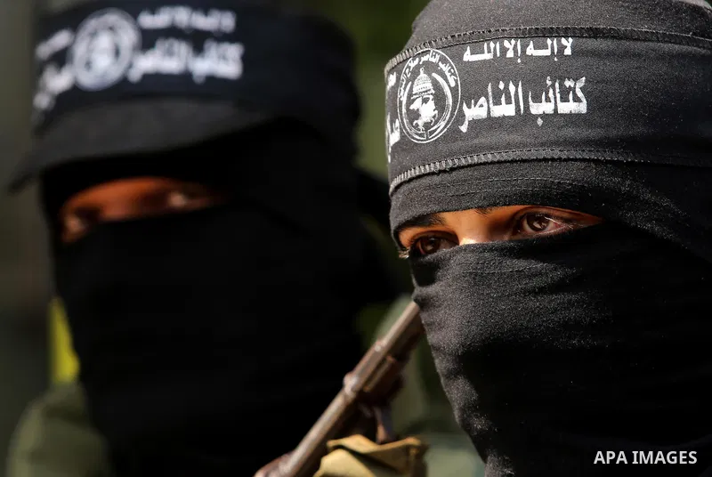 Palestinian militants of the Nasser Salah al-Din Brigades the military wing of the Popular Resistance movement hold their weapons during a press conference, in Gaza City on April 15, 2017. Photo by Ashraf Amra
