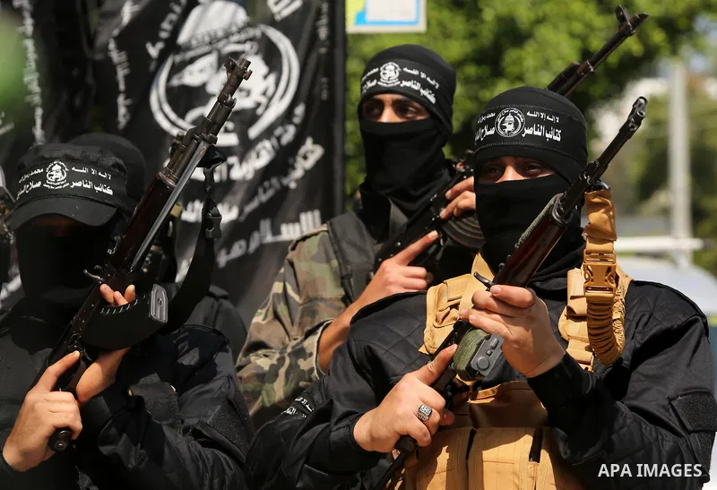 Palestinian militants of the Nasser Salah al-Din Brigades the military wing of the Popular Resistance movement hold their weapons during a press conference, in Gaza City on April 15, 2017. Photo by Ashraf Amra