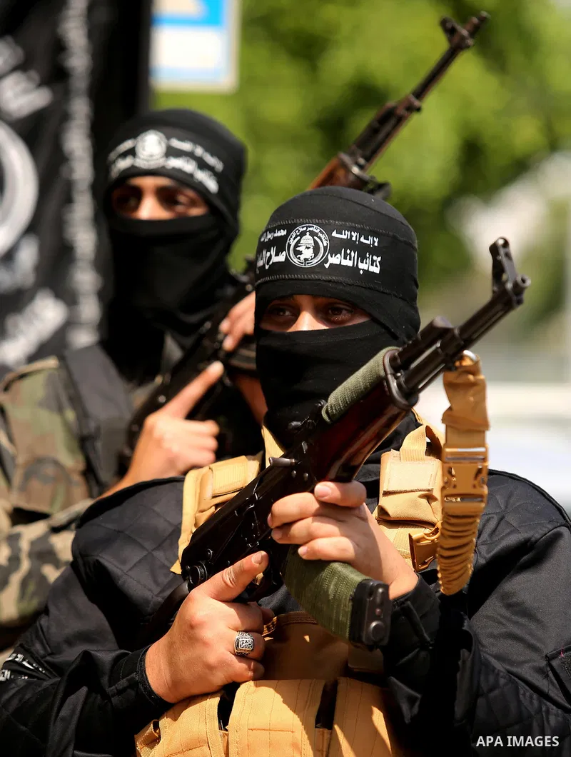 Palestinian militants of the Nasser Salah al-Din Brigades the military wing of the Popular Resistance movement hold their weapons during a press conference, in Gaza City on April 15, 2017. Photo by Ashraf Amra