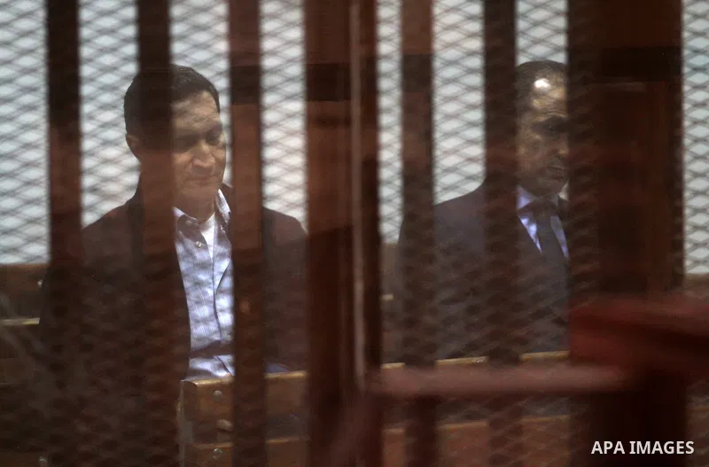 Alaa and Gamal Mubarak, the sons of former president Hosni Mubarak sit in a courtroom cage during their trial in ''Stock Market Manipulation'' case, in Cairo, Egypt, on April 15, 2017. Gamal and Alaa Mubarak and six othe...
