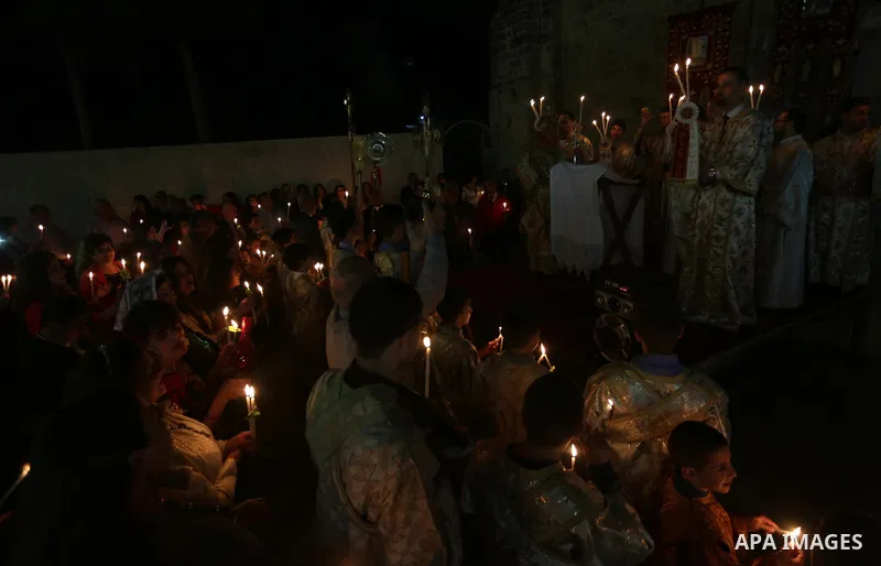 Orthodox Christian worshippers attend a prayer during the Easter Eve mass at the St. Porphyrios church in Gaza City, Saturday, April 15, 2017. Christians have gathered at the church for the fire ceremony that celebrates...