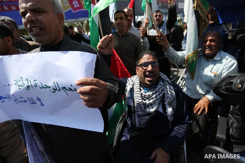 Palestinians shout slogans and hold banners during a demonstration to calling for an end in the political division and the national reconciliation, in Gaza city on April 16, 2017. Photo by Ashraf Amra