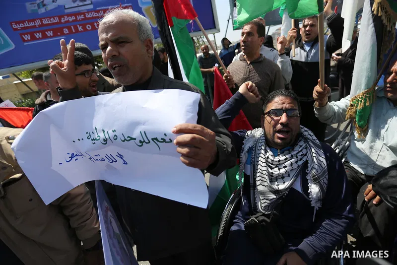 Palestinians shout slogans and hold banners during a demonstration to calling for an end in the political division and the national reconciliation, in Gaza city on April 16, 2017. Photo by Ashraf Amra