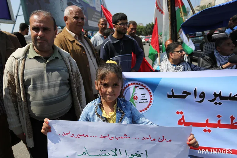 Palestinians shout slogans and hold banners during a demonstration to calling for an end in the political division and the national reconciliation, in Gaza city on April 16, 2017. Photo by Ashraf Amra