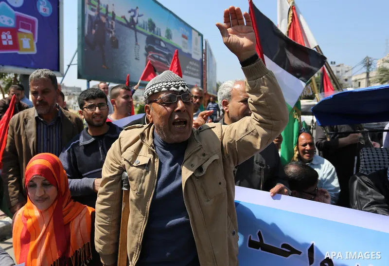 Palestinians shout slogans and hold banners during a demonstration to calling for an end in the political division and the national reconciliation, in Gaza city on April 16, 2017. Photo by Ashraf Amra