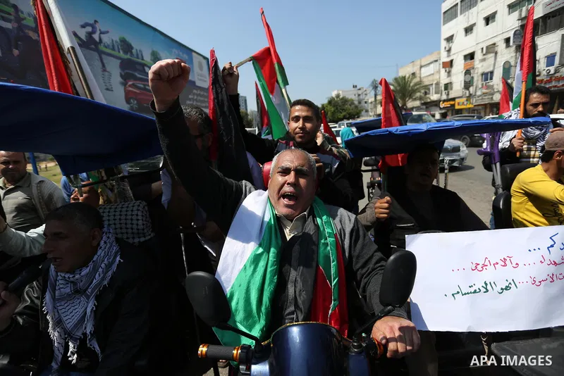 Palestinians shout slogans and hold banners during a demonstration to calling for an end in the political division and the national reconciliation, in Gaza city on April 16, 2017. Photo by Ashraf Amra