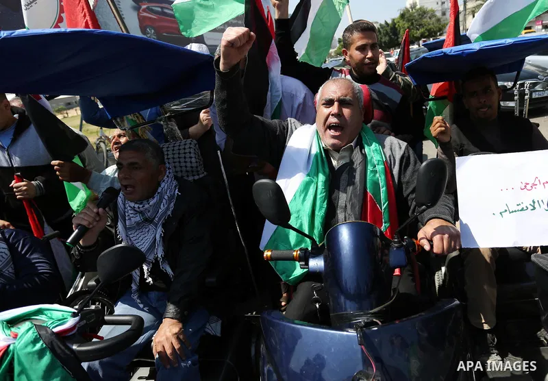 Palestinians shout slogans and hold banners during a demonstration to calling for an end in the political division and the national reconciliation, in Gaza city on April 16, 2017. Photo by Ashraf Amra