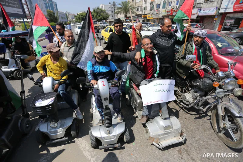 Palestinians shout slogans and hold banners during a demonstration to calling for an end in the political division and the national reconciliation, in Gaza city on April 16, 2017. Photo by Ashraf Amra