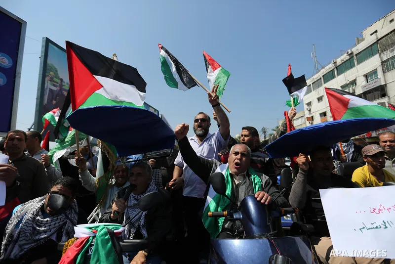 Palestinians shout slogans and hold banners during a demonstration to calling for an end in the political division and the national reconciliation, in Gaza city on April 16, 2017. Photo by Ashraf Amra