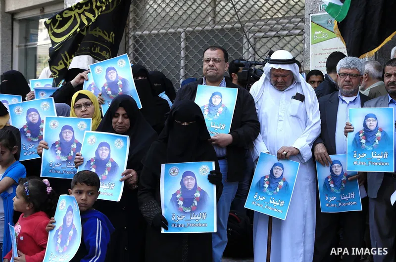 Palestinian supporters of the Islamic Jihad Movement hold posters bearing a portrait of Palestinian Lina al-Jarbouni, the longest-serving woman prisoner in Israeli jails, after she was released from the Israeli Hasharon...