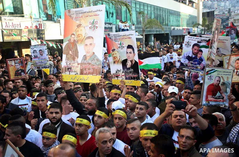 Palestinians hold pictures of relatives held in Israeli jails during a rally marking Palestinian Prisoner Day in the West Bank city of Nablus April 16, 2017. Photo by Stringer