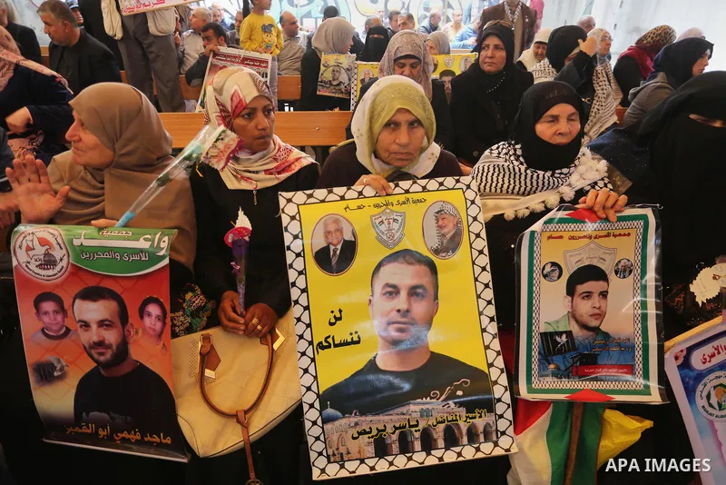 Palestinians hold placards during a protest to show solidarity with Palestinian prisoners held in Israeli Jails, in front of Red cross office in Gaza city, on April 17, 2017. Photo by Mohammed Asad